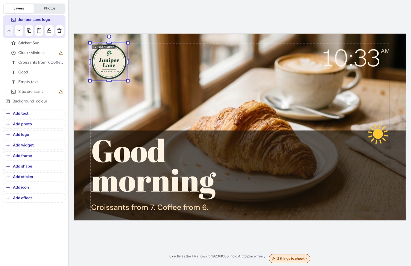 A cafe’s round logo just added to the top corner of a Good morning sign with a croissant and a clock