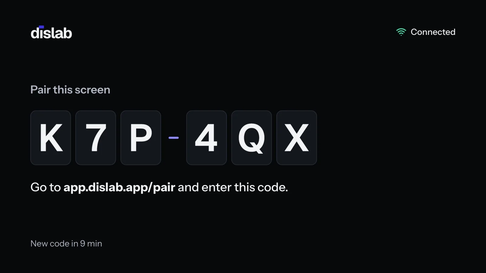 The TV showing Dislab’s pairing screen: Pair this screen, a 6-character code, and Go to app.dislab.app/pair and enter this code.